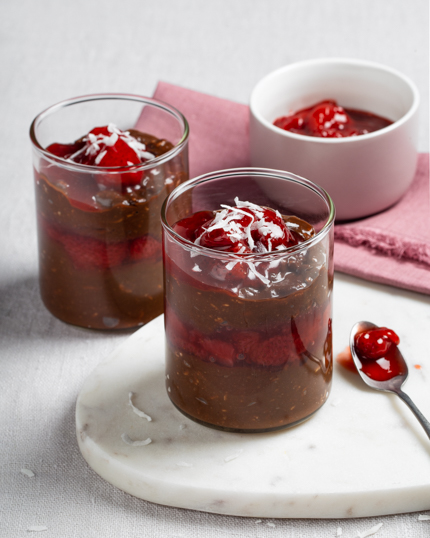 overnight oats and compote in 2 jars with spoon beside foreground jar