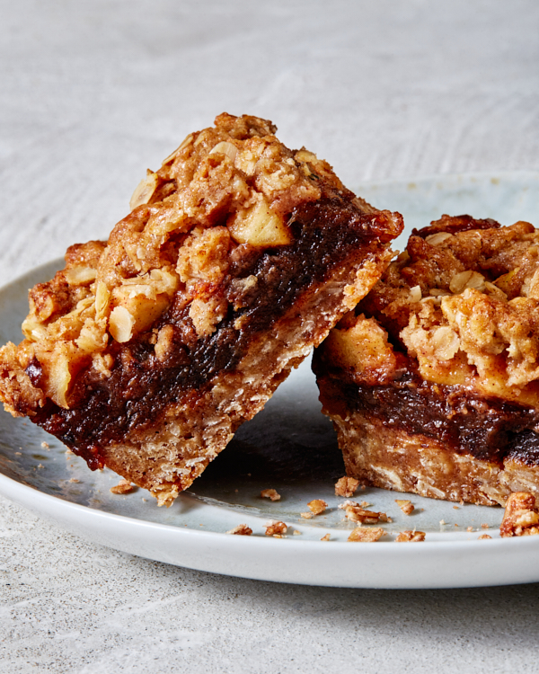 Two Apple Date Crumble Bars served on a grey-blue plate, with one leaning on the other