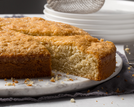 Apple Brandy Cake on a marble platter with one slice cut