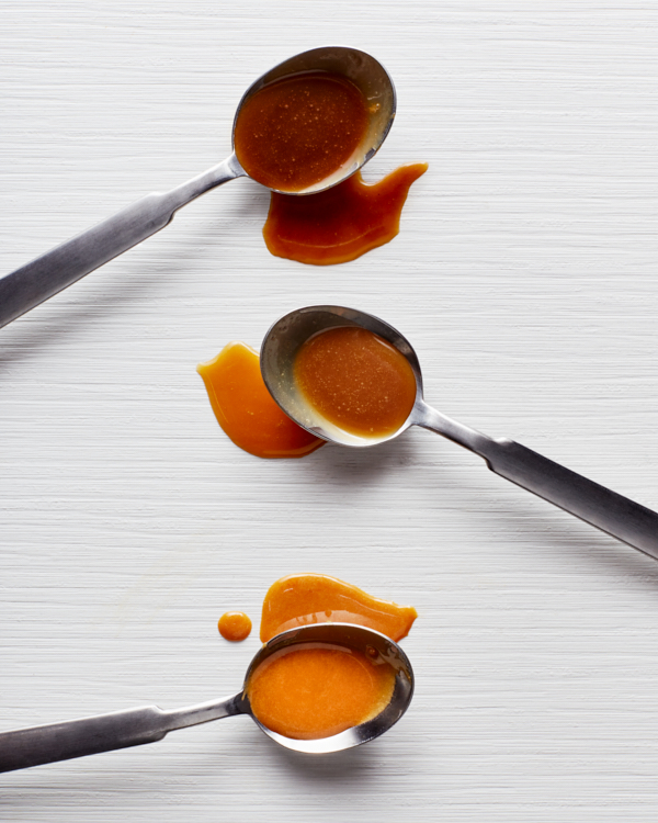 Three spoons of salted caramel sauce; one with sea salt, one with miso, and one with soy, shown from darkest to lightest.