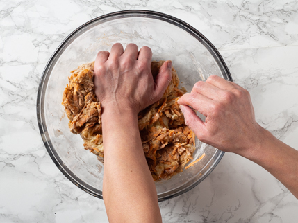 Kneading dough by hand in a glass bowl