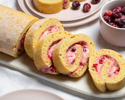 Slices of vanilla Swiss roll filled with cranberries and cream
