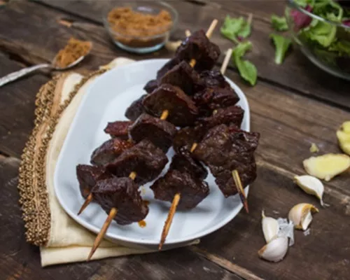 Teriyaki beef skewers on a white plate