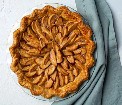 Full dutch apple pie sitting on a blue napkin