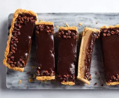 Slices of the chocolate chestnut ganache tart on a grey marble slab